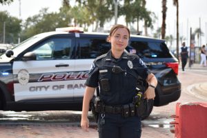 Female police officer in front of police vehicle