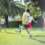Kids playing soccer in the park.